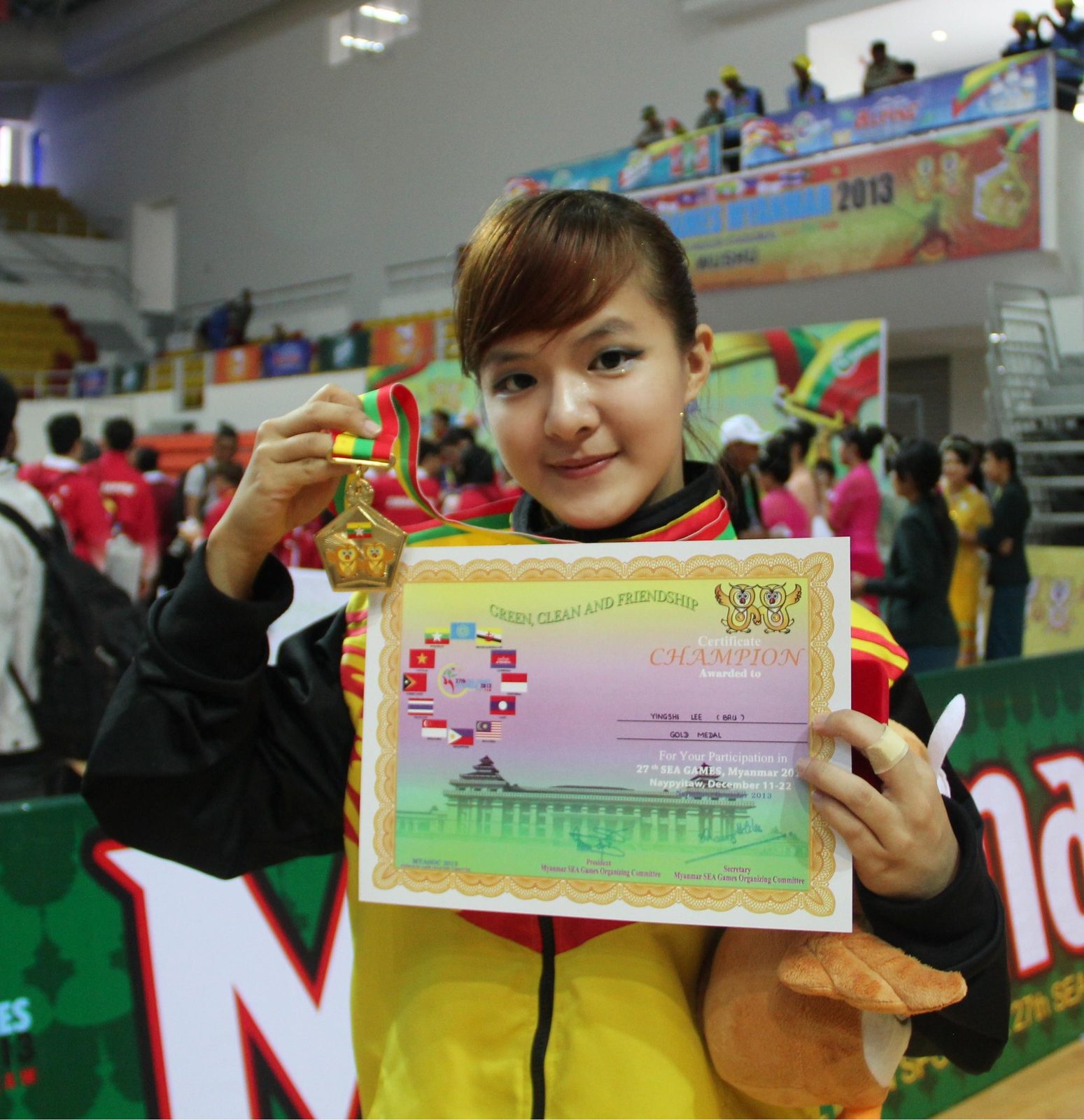 Lee Ying Shi holding her SEA Games 2013 gold medal and champion certificate